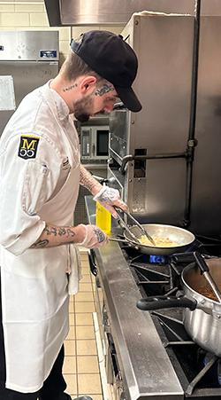 Students cooking at a stove in the food for thought kitchens